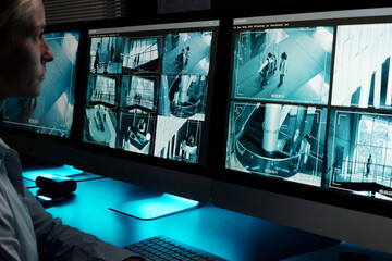 Poster - Focus on desktop computer monitors with cctv video system on screens standing in front of young working female guard