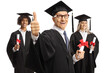 © Ljupco Smokovski - College graduate students and an elderly man in graduation gowns holding diplomas and giving thumbs up