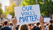 © Irina - Demonstrator holding sign 'Our Voices Matter' at social justice protest in city