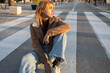 © ADDICTIVE STOCK - Mixed race woman sitting on a crosswalk in casual attire
