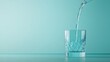 © DIAHIMAGESNEW - Water pouring into a crystal glass on a teal background.