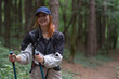 © Dusan Kostic - Young woman tourist with backpack and walking stick hiking the forest path