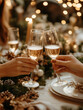 © AISTEL - Close-up of hands toasting with champagne flutes during a festive New Year celebration