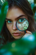 © stanhert - A woman looking through a magnifying glass in the woods