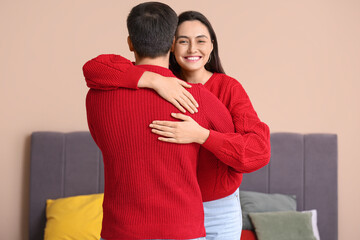 Canvas Print - Young woman hugging her husband in bedroom on autumn day