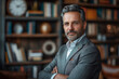 © PhotoProAD - A man in a gray suit is standing in front of a bookshelf