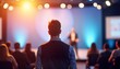 © Viktor - Audience members attentively listen to speaker giving presentation at business event. People focused on speaker in foreground event space, people softly blurred. Professional atmosphere. Learning