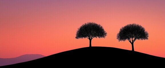 Two trees silhouetted on a hill at sunset.