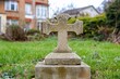 © Arx PhotoStock - A weathered stone cross grave marker in a grassy area.
