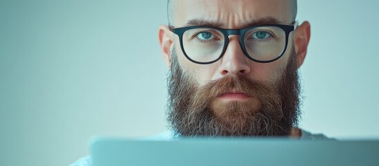 Poster - focused bald man with glasses and beard working on laptop close-up top view with blank space for tex
