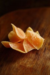 Poster - Close-up of several pieces of dried orange slices on a wooden surface.