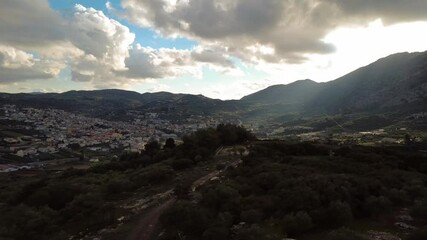 Poster - Scenic view of a town with mountainous view under a cloudy sky