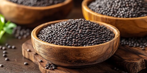 Poster - Close up of wooden bowls filled with black beluga lentils, showcasing their unique texture. Black beluga lentils are a healthy protein source, ideal for vegan and vegetarian diets.