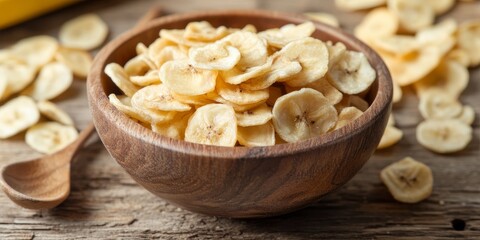 Poster - Dried banana chips are arranged in a wooden bowl accompanied by a serving spoon, set against a background of distressed textured wood shiplap boards, creating a visually appealing display of dried