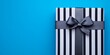 © ShStock - Closeup of a striped gift box adorned with a grey ribbon, set against a vibrant blue background, perfect for conveying the joy of gifting and celebration. A charming striped gift box design.