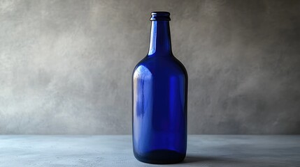 Poster - A sleek blue beer bottle with an empty label, isolated on a smooth grey background, ideal for branding, mockups, or design presentations
