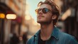 © HISTOCK - Young man wearing sunglasses looking up in a city street at sunset