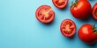 © Lala - Top view featuring both cut and whole tomatoes on a blue backdrop, perfect for showcasing fresh tomatoes and their vibrant colors, with ample copy space for creative design.