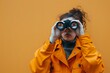 © Yuliana - Woman in Orange Jacket Uses Binoculars to Explore Distant Horizons, Seeking Adventure and New Discoveries in the Vast Unknown, Intrigued by the Mystery and Promise of Exploration.