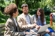 © Srdjan - Group of young business people sitting on the bench outside office building in downtown district, talking discussing and resting till waiting the staff meeting and presentation of new project ideas.