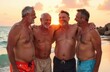 © YULIA - A group of men with different body types on the beach demonstrate body positivity and friendly support. Embracing diversity