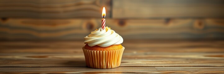 Wall Mural - Birthday cupcake with a single candle on a rustic wooden table setting