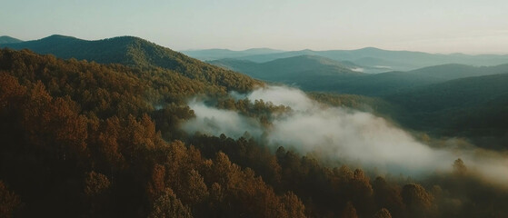 Poster - Cinematic view of fog-covered mountains with contrasting colors at dawn