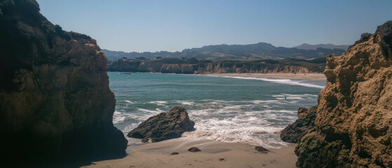 Aufkleber - Serene beach landscape with gentle waves and rocky cliffs under clear blue sky