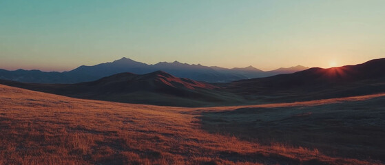 Aufkleber - Soft rolling hills bask in the warm glow of an early sunrise over distant mountains