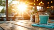 ©  Shomixer - A sunset glow illuminates a wooden table with a glass of beverage, pepper and salt, creating a picturesque moment filled with warmth, serenity, and a reflective mood.