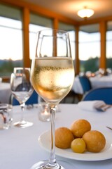 Wall Mural - Sparkling wine glass with bread rolls on a table in a restaurant.