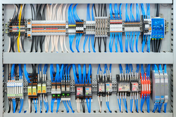 Poster - Large electrical panel with many wires and switches is blue and white. The panel is filled with various switches and wires, making it a complex and intricate piece of machinery