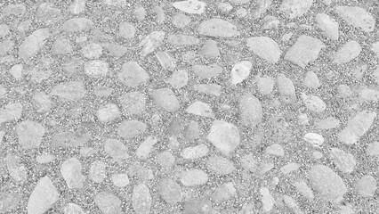 Fototapete - Gray stone surface with many small stones as a flat textured background top view. Stones are scattered all over the surface. The surface is not smooth and has a rough texture.