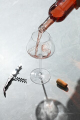 Wall Mural - Pouring rose wine into glass at grey marble table