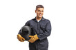 © Ljupco Smokovski - Welder in a uniform holding a protective helmet and smiling at camera
