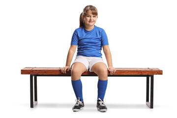 Sticker - Girl in football sportswear sitting on a bench