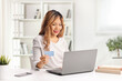© Ljupco Smokovski - Asian woman paying bills from home with a laptop computer