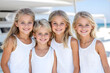 © Наталья Лазарева - Smiling group of blonde children in white clothing outdoors near the sea, perfect for themes of family, friendship, summer, happiness, and carefree childhood moments