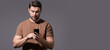 © Volodymyr - Portrait of handsome man using smartphone, chatting, making post on social media. Business man call on phone isolated over studio background. Banner for header, copy space.