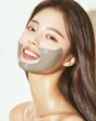 © xbzz - Playful korean beauty smiling woman with clay mask in natural light indoor lifestyle focus