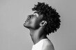 © LimeSky - Attractive curly haired Black man in a t shirt against a gray backdrop side profile