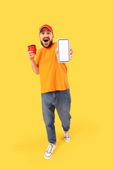 Wall Mural - young man with blank mobile phone and soda on yellow background