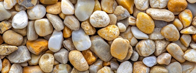 Aufkleber - Close-up of smooth, multicolored pebbles in yellow, beige, and white tones.