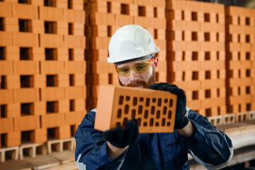 Wall Mural - Happy worker man carries out quality control of product. Bricks ceramics factory process