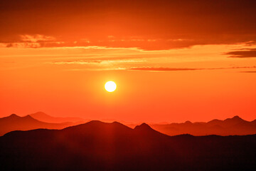 Wall Mural - the sun is setting over a mountain range