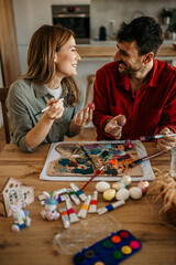 Wall Mural - Mid aged couple painting Easter eggs while surrounded by festive decor