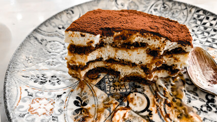 Traditional Italian Tiramisu dessert square portion on ceramic plate in kuwait