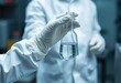 © Habibur - A scientist hand with a white PPE suit and nitrile gloves collect sample waste water into a flask for laboratory water analysis, industrial and environmental concept
