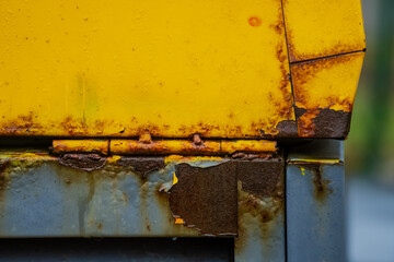 Yellow industrial machinery close up of color peeling of and rust showing