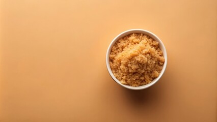 Poster - A close-up view of brown sugar in a white bowl against a soft orange background